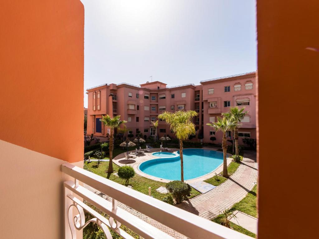 un balcone con vista sulla piscina. di New Modern Apartment in Marrakech - Netflix - WiFi a Marrakech