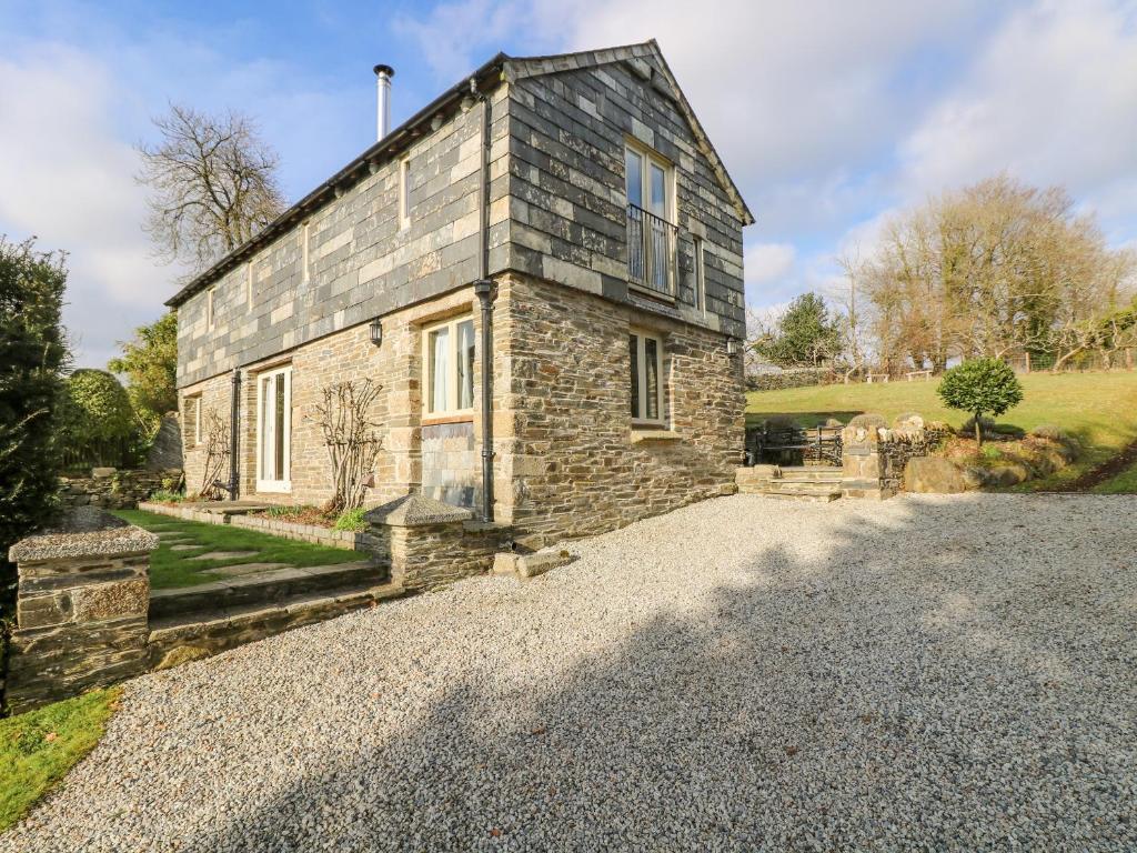 an old stone house on a gravel road at Woodfield Coach House in Merrymeet