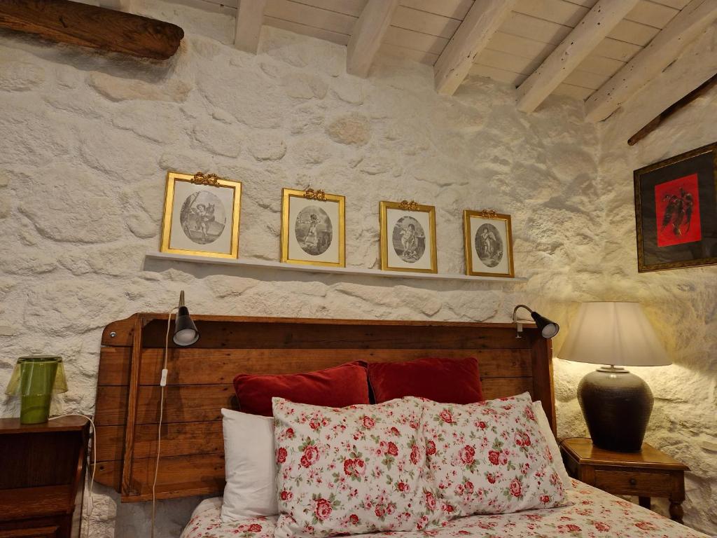 a bedroom with a bed and four pictures on the wall at El Atalanto in Madrigal de la Vera