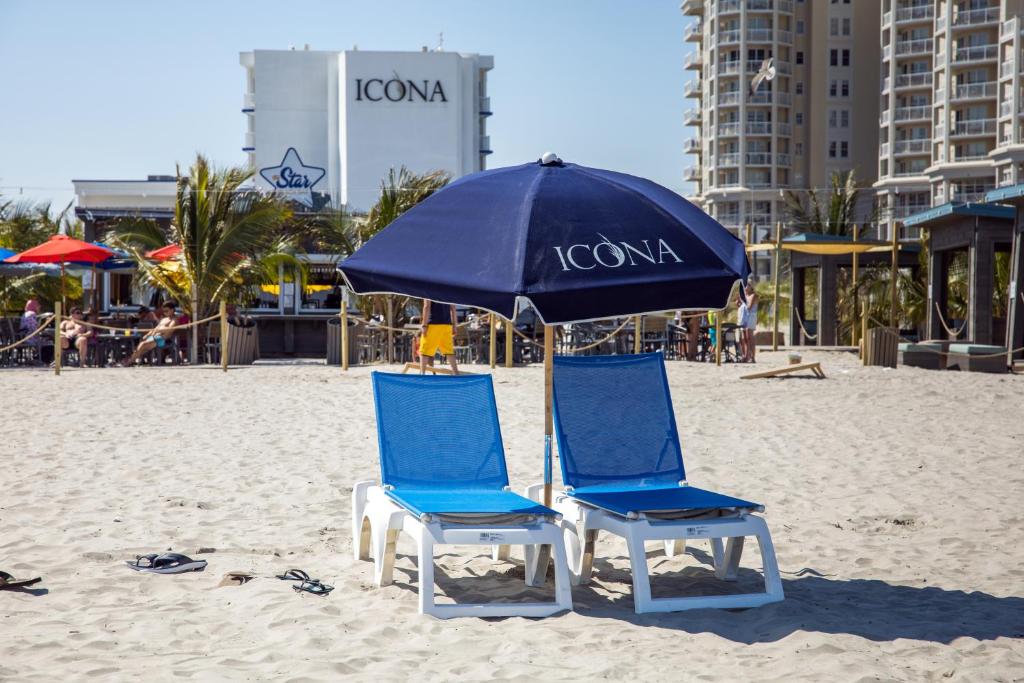 zwei Stühle und ein Sonnenschirm am Strand in der Unterkunft ICONA Diamond Beach in Wildwood Crest