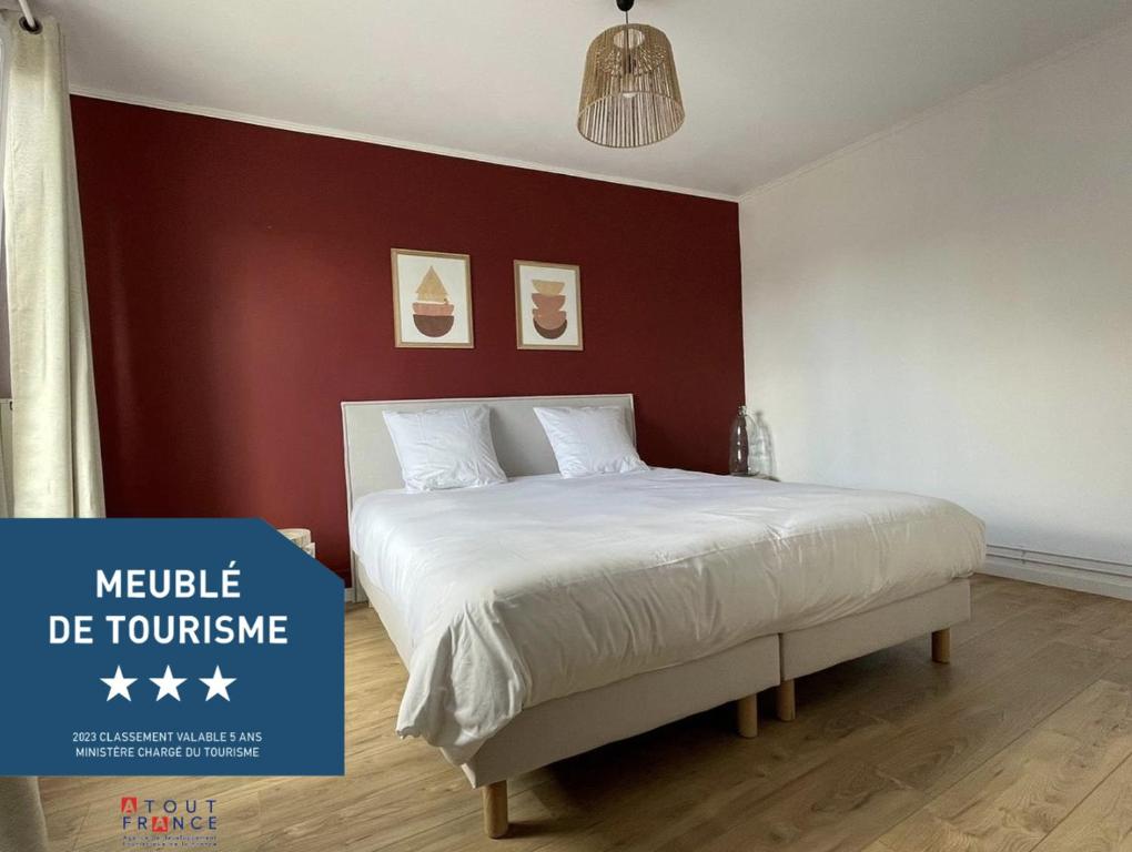 ein Schlafzimmer mit einem Bett mit einer roten Wand in der Unterkunft Le W - Appart vintage in Épernay
