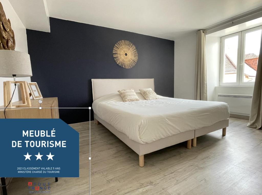 a bedroom with a bed and a blue wall at Les Gouttes d'Or in Pierry