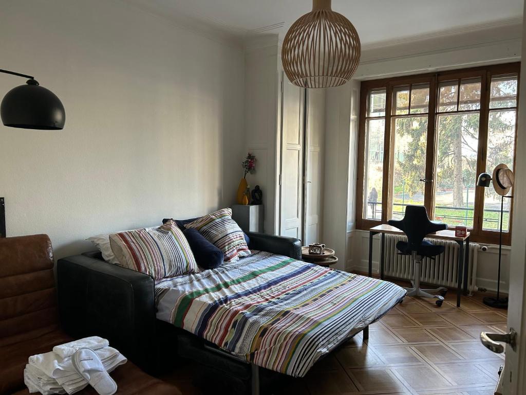 ein Wohnzimmer mit einem Sofa und einem großen Fenster in der Unterkunft Chambre, bedroom - Perle du Lac, Geneva in Genf