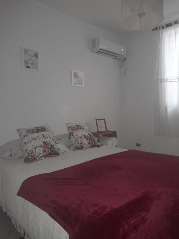 1 dormitorio blanco con 1 cama grande con manta roja en E.Z Céntrico, Mendoza en Mendoza