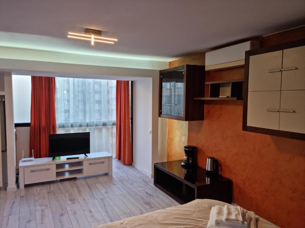 sypialnia z łóżkiem, telewizorem i oknem w obiekcie Nerva Traian Studio w Bukareszcie
