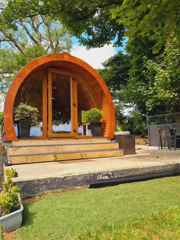 a circular building with an arched window in a yard at Loughmourne Glamping Pod 