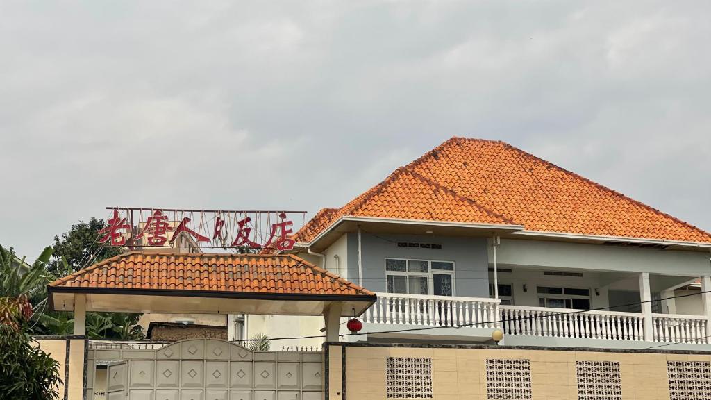 uma casa com um telhado laranja e uma cerca em Lao Tangren Guest House em Kigali