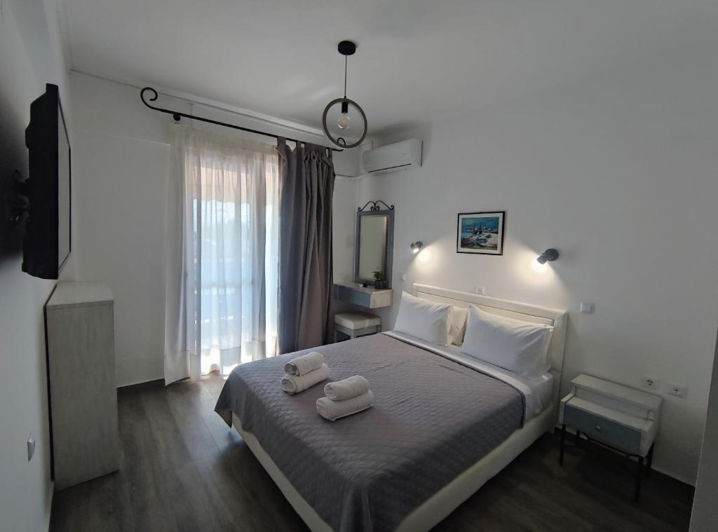 ein Schlafzimmer mit einem Bett mit zwei Handtüchern darauf in der Unterkunft Syrtaki Hotel in Ofrynio