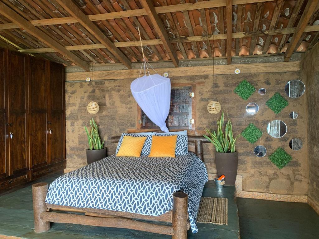 a bedroom with a bed in a room with plants at Cabaña Tamanique in Tamanique