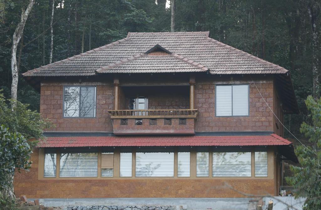 a house with a balcony on top of it at Green Garden Wayanad Villas in Vayittiri