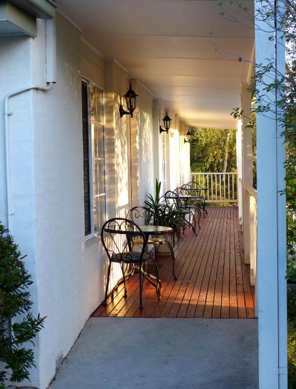 a porch with chairs and a table on a house at Yarra Gables in Healesville