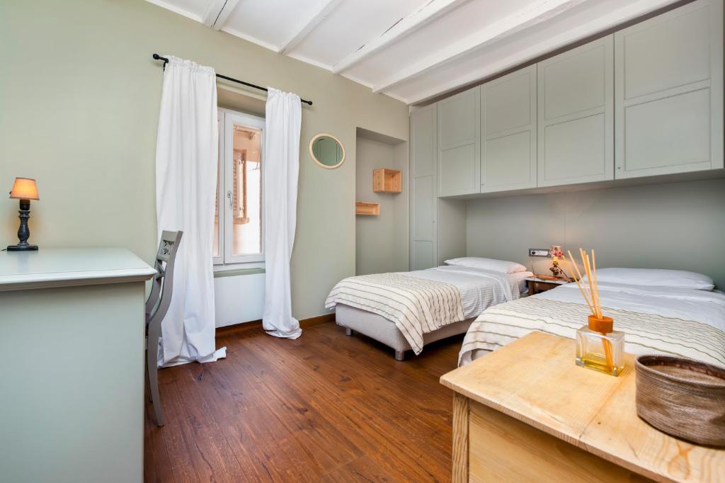 a bedroom with two beds and a kitchen with a table at Apartment Mediterraneo in Rovinj