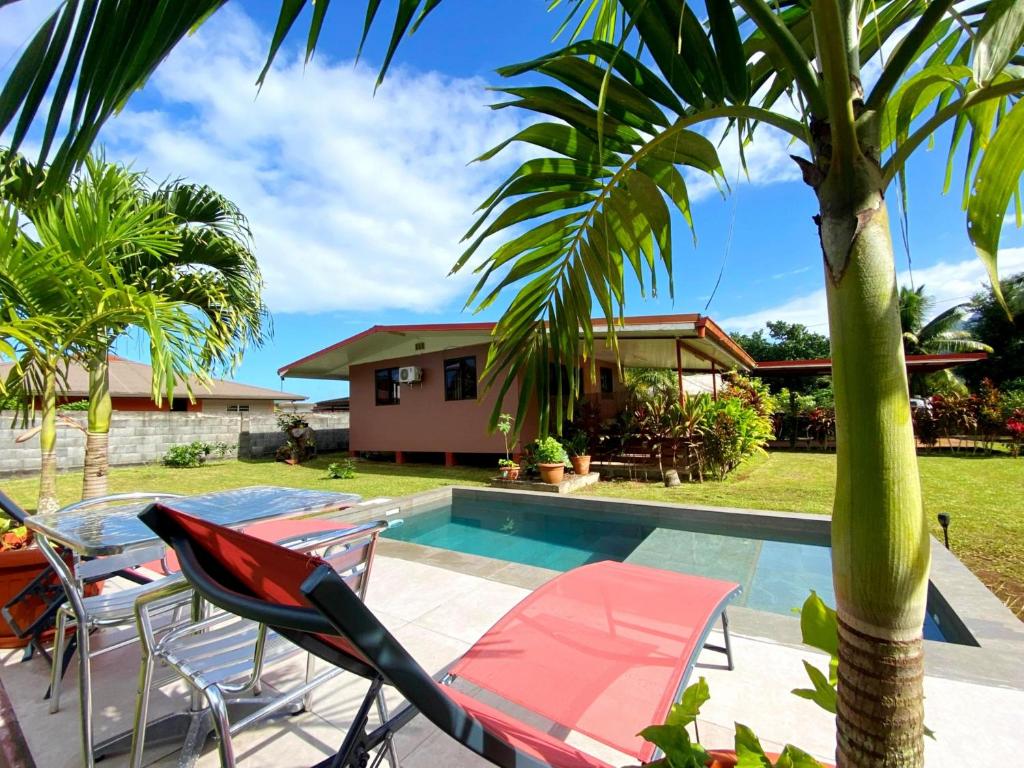 Taravao的住宿－TAHITI - Fare Matavai Hoe，一个带游泳池和棕榈树的别墅