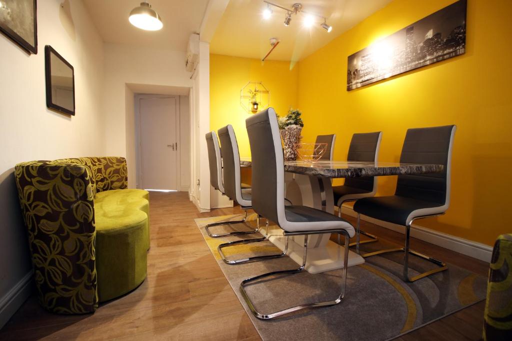 una sala d'attesa con pareti gialle e tavolo e sedie di Stunning 4 Bedroom Flat - Near City Centre a Swansea