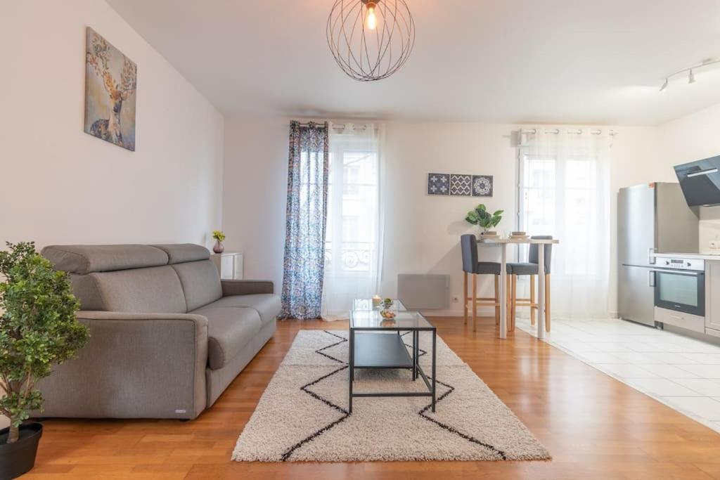 ein Wohnzimmer mit einem Sofa und einem Tisch in der Unterkunft Le Chaleureux-T2-47m2-Disney in Serris