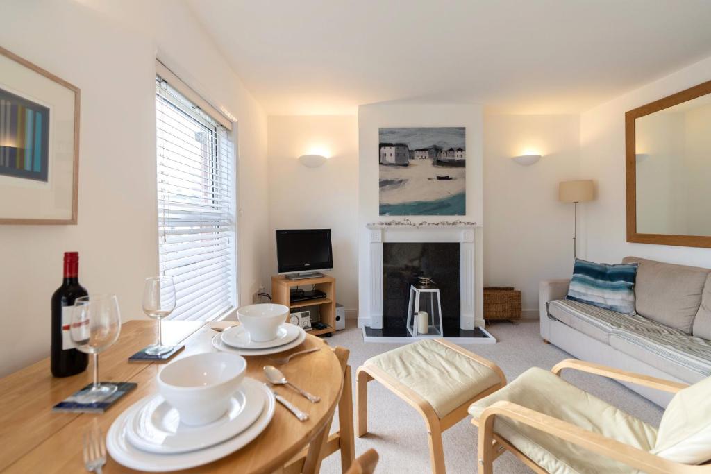 uma sala de estar com uma mesa e um sofá em The Bolthole em Aldeburgh