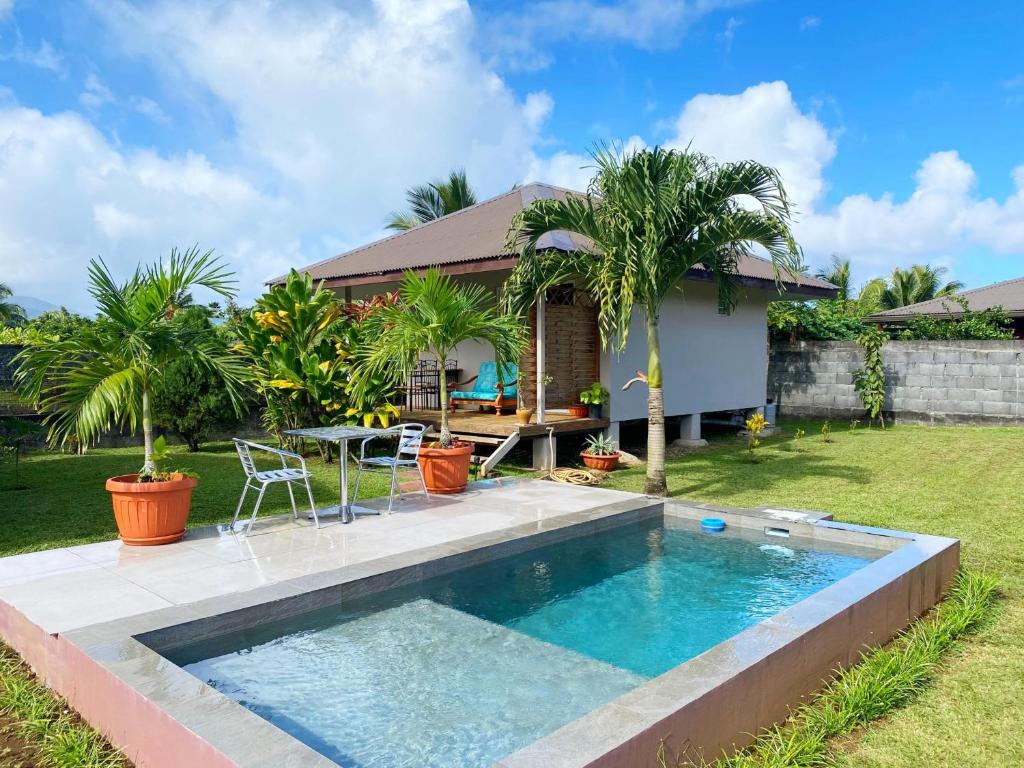 un patio trasero con piscina y una casa en TAHITI - Fare Matavai Piti, en Taravao