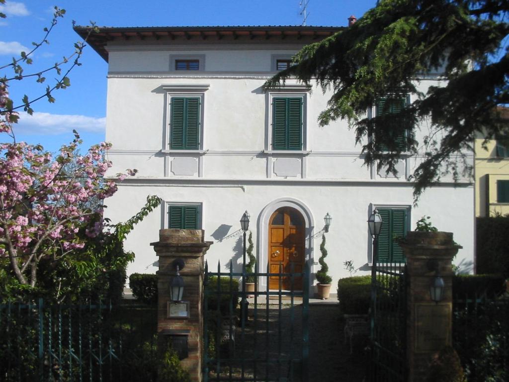 una casa blanca con una puerta delante de ella en Villa Della Certosa, en Gambassi Terme