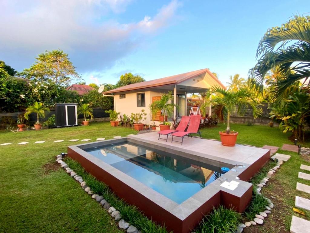 un patio trasero con piscina y una casa en TAHITI - Fare Matavai Toru en Taravao