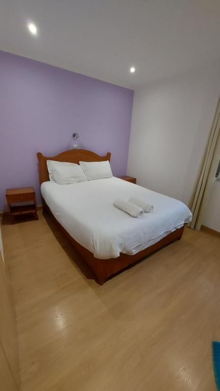 - une chambre avec un grand lit et des draps blancs dans l'établissement Residencial Condado, à Faro