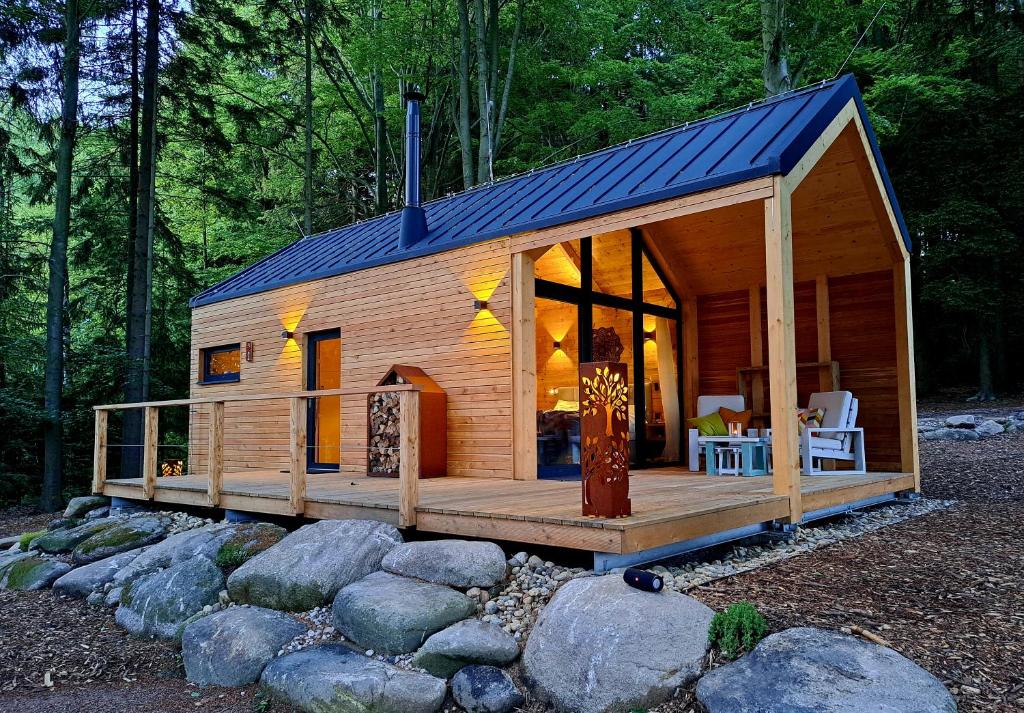 uma pequena cabina de madeira com um grande deque em Forest Garden Romance 