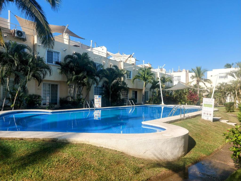 una gran piscina frente a un edificio en Casa Azur- vista al mar y alberca en Acapulco
