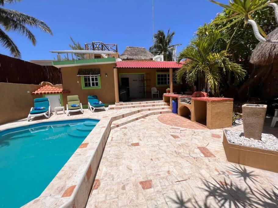 una casa con piscina frente a una casa en Casa Tortuga Verde, en Chuburná