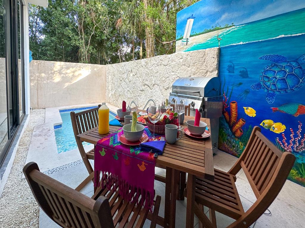 uma mesa e cadeiras com uma refeição num pátio em Casa Debra em Puerto Morelos