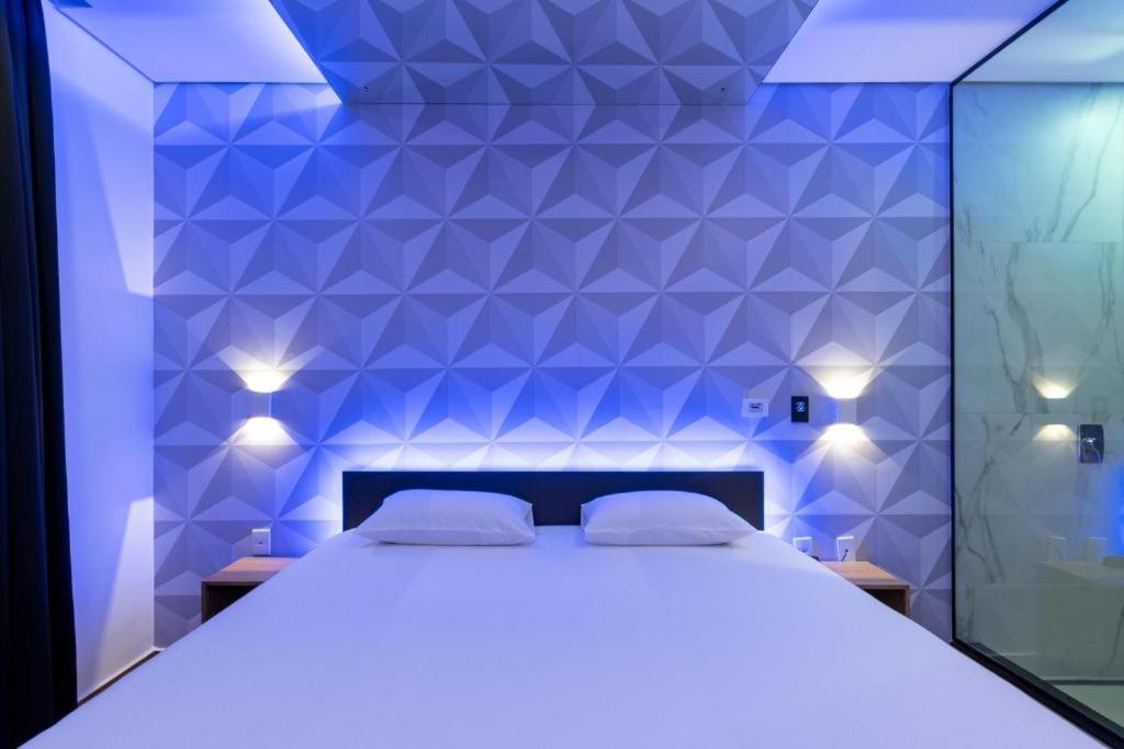 um quarto com uma cama branca e uma parede azul em mega casa em Arcoverde