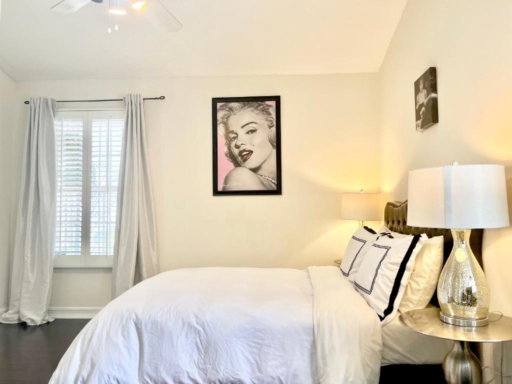 a white bedroom with a bed and a window at Hollywood Hills Homestay in Los Angeles