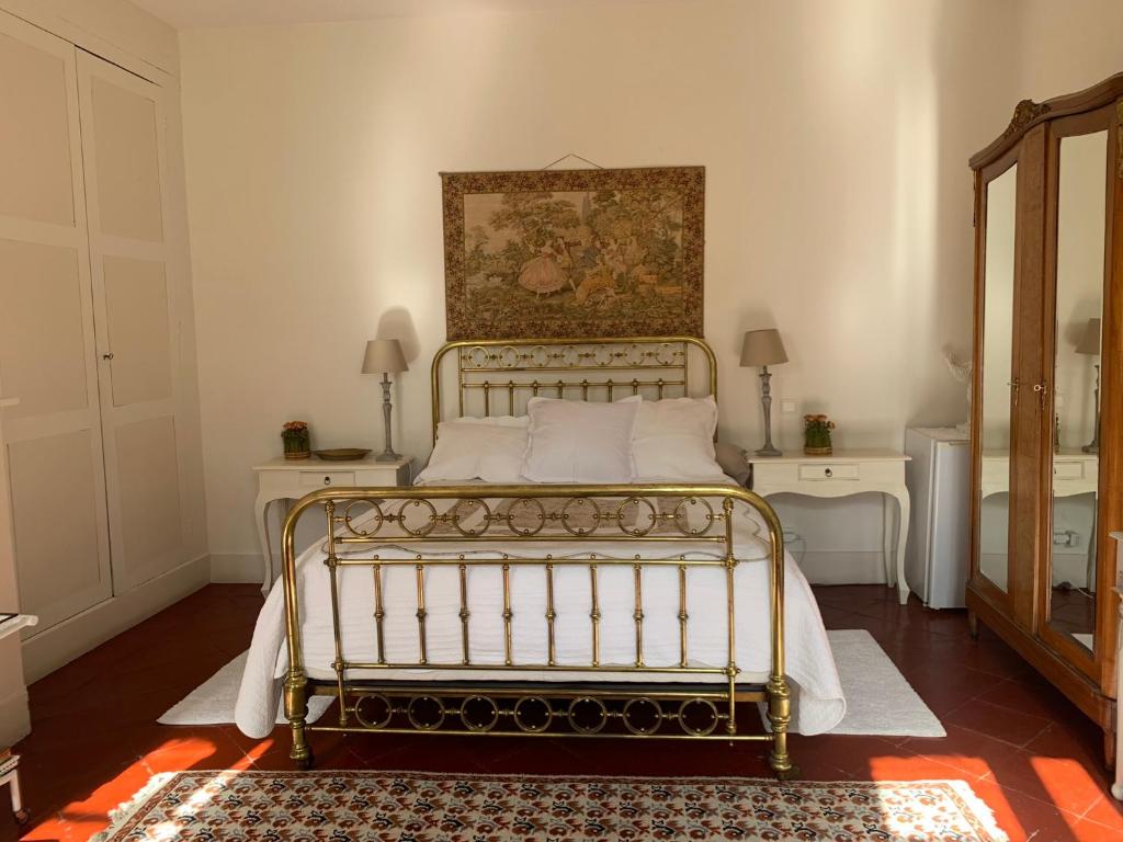 a bed in a bedroom with two tables and a mirror at Le Moulin du Carla in Lavaur