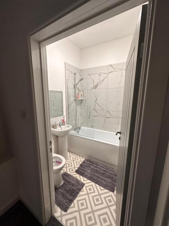 a bathroom with a tub and a toilet and a sink at City Blessed Aptm 2 with free parking in North Shields