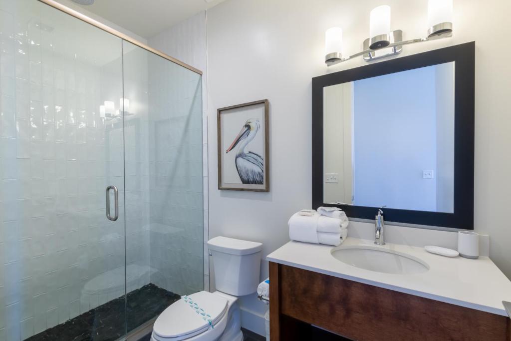 a bathroom with a toilet and a sink and a shower at Elegant 4 BR Luxury Condo with Rooftop Pool Next to the Hangout in Gulf Shores