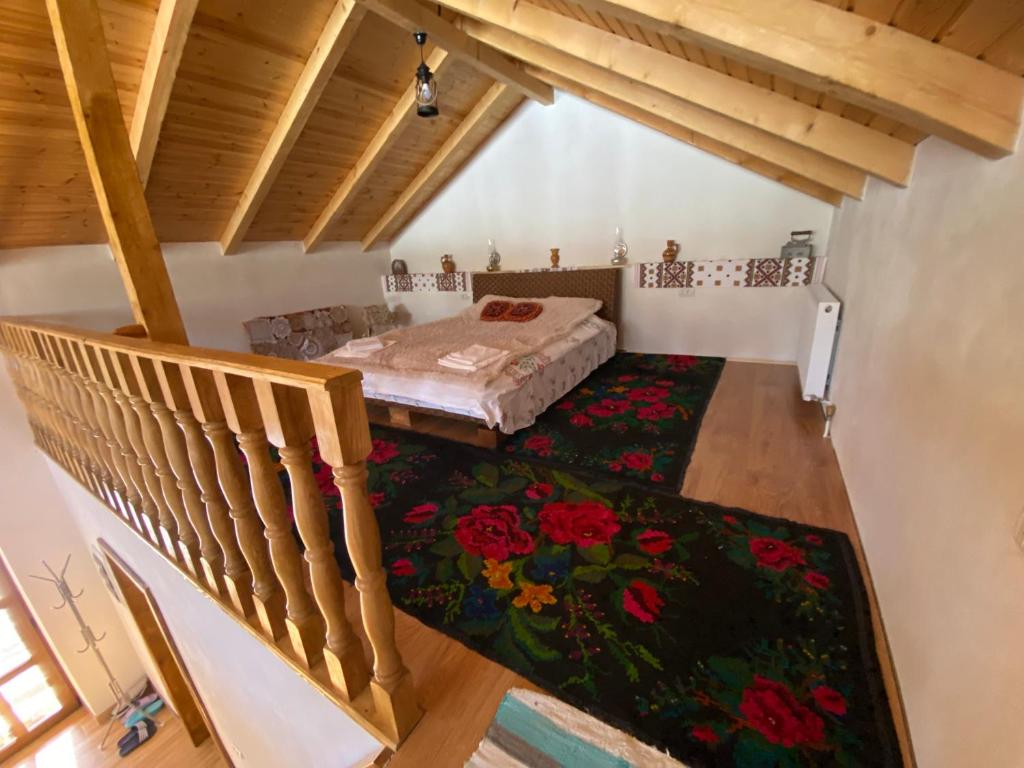 an attic room with a bed and a staircase at Pensiunea Casa Țărănească in Satu Bătrîn