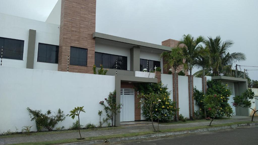 een wit gebouw met palmbomen ervoor bij Casa Aruana in Aracaju