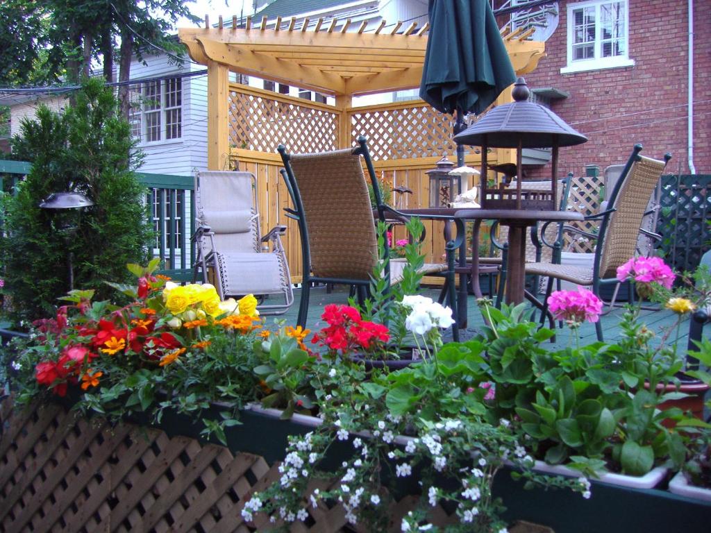 a patio with a bunch of flowers and an umbrella at B&B Le Transit in Quebec City