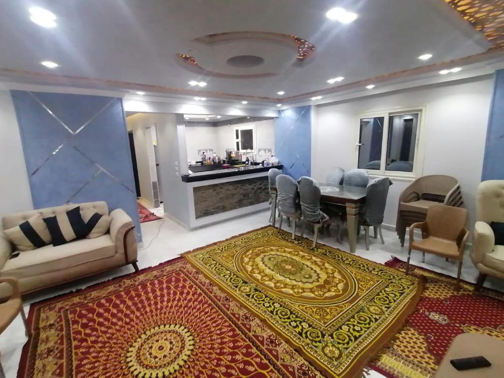 ein Wohnzimmer mit einem Teppich, einem Tisch und Stühlen in der Unterkunft apartment Mokattam Cairo in Kairo