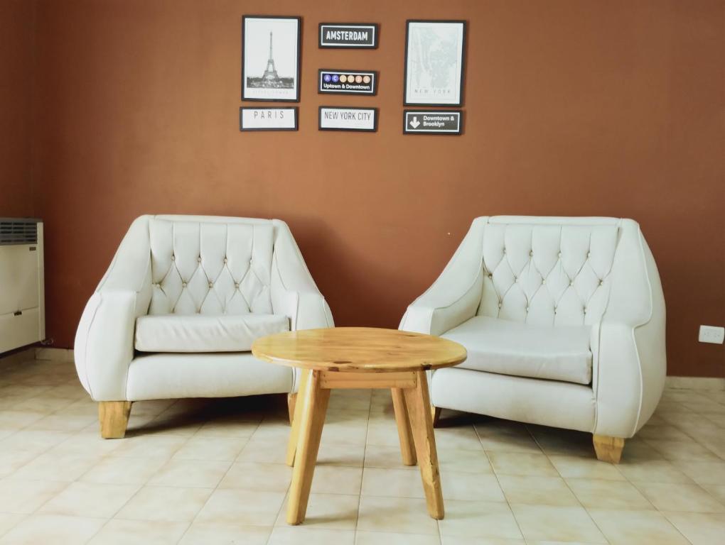 twee witte stoelen en een salontafel in een kamer bij Cómodo Departamento de 2 habitaciones, con excelente ubicación in San Rafael