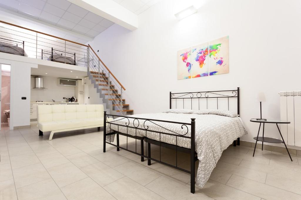 1 dormitorio con cama, sofá y escalera en Appartamenti "Il Delfino", en Lecce
