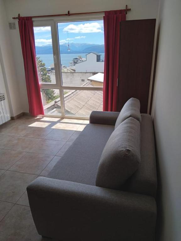 a living room with a couch and a large window at Departamento JS - Centro Bariloche in San Carlos de Bariloche