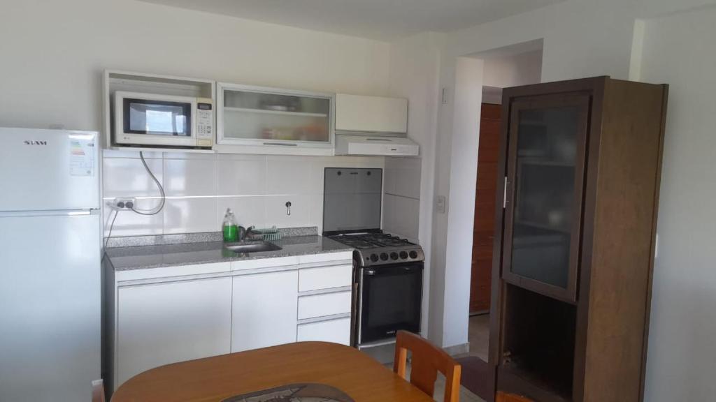 Il comprend une cuisine équipée d'un réfrigérateur et d'une cuisinière. four supérieur dans l'établissement Departamento JS - Centro Bariloche, à San Carlos de Bariloche