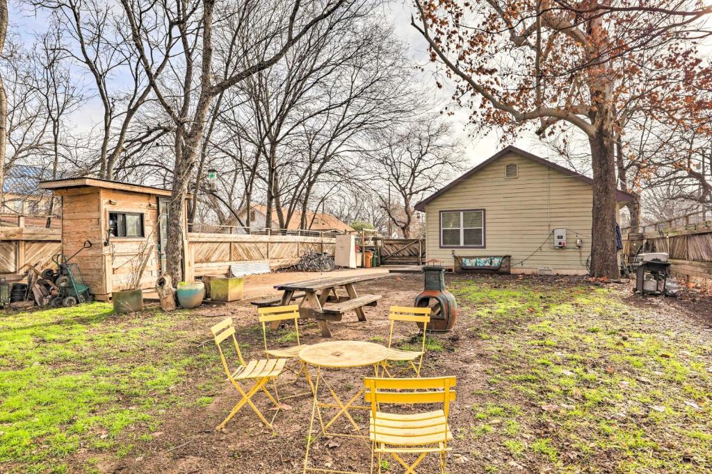 een picknicktafel en stoelen in een tuin met een huis bij Pet-Friendly Austin Home with Private Yard! in Austin