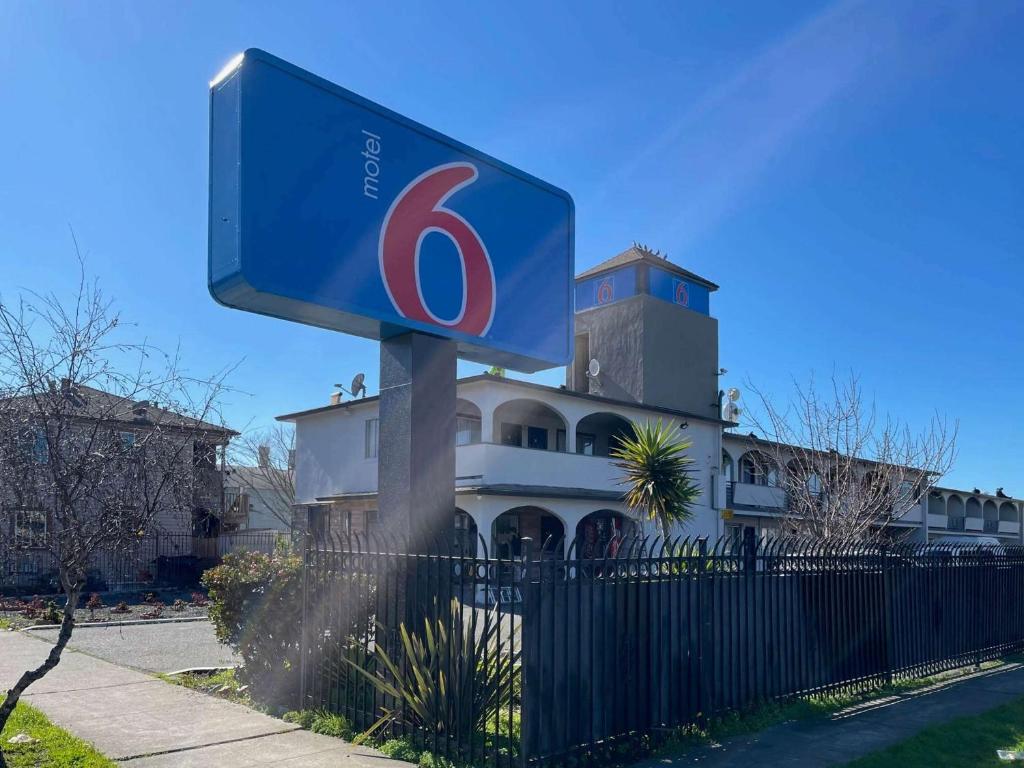 a blue sign on a pole in front of a building at Motel 6 Richmond CA Civic Center in Richmond