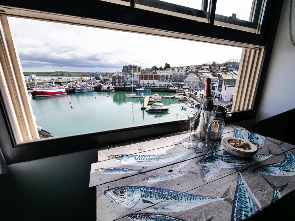 a window with a view of a harbor with boats at Padstow Escapes - Pajar Luxury Penthouse Apartment in Padstow