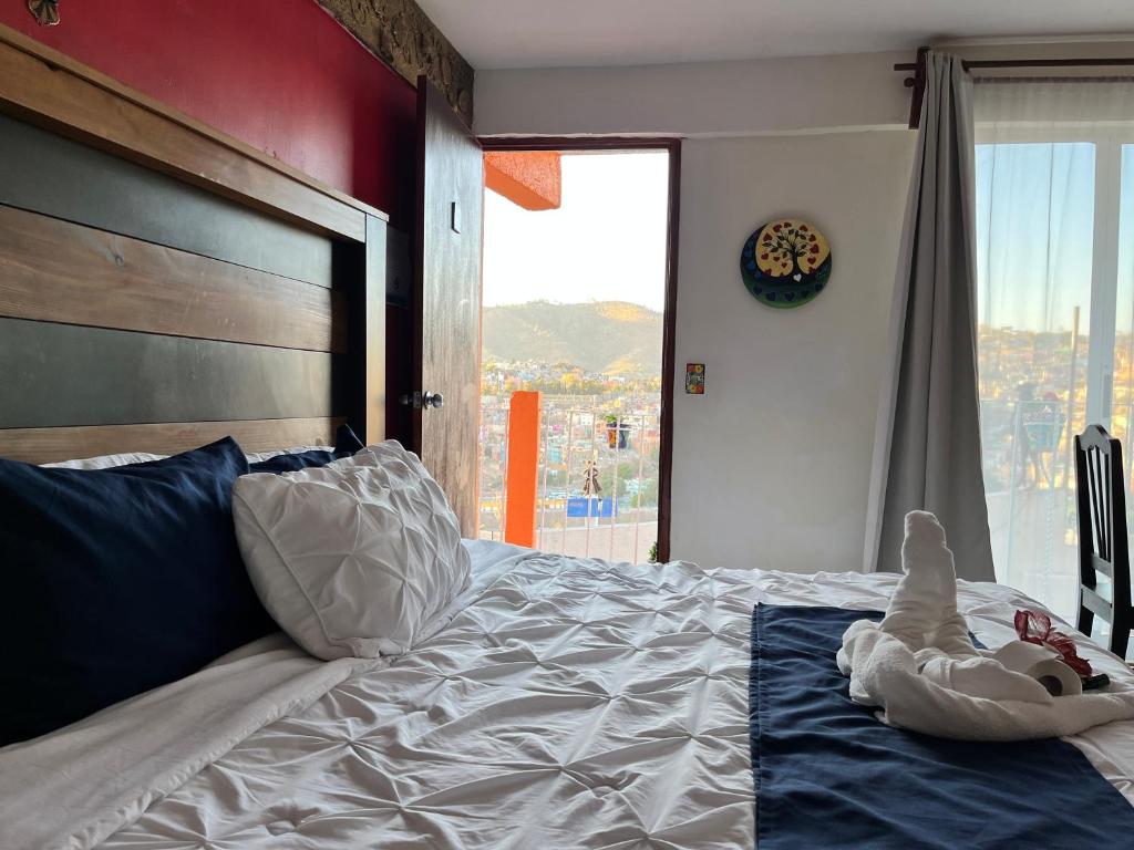 a bedroom with a large bed with a large window at HOTEL CASONA DE LAS AVES in Guanajuato