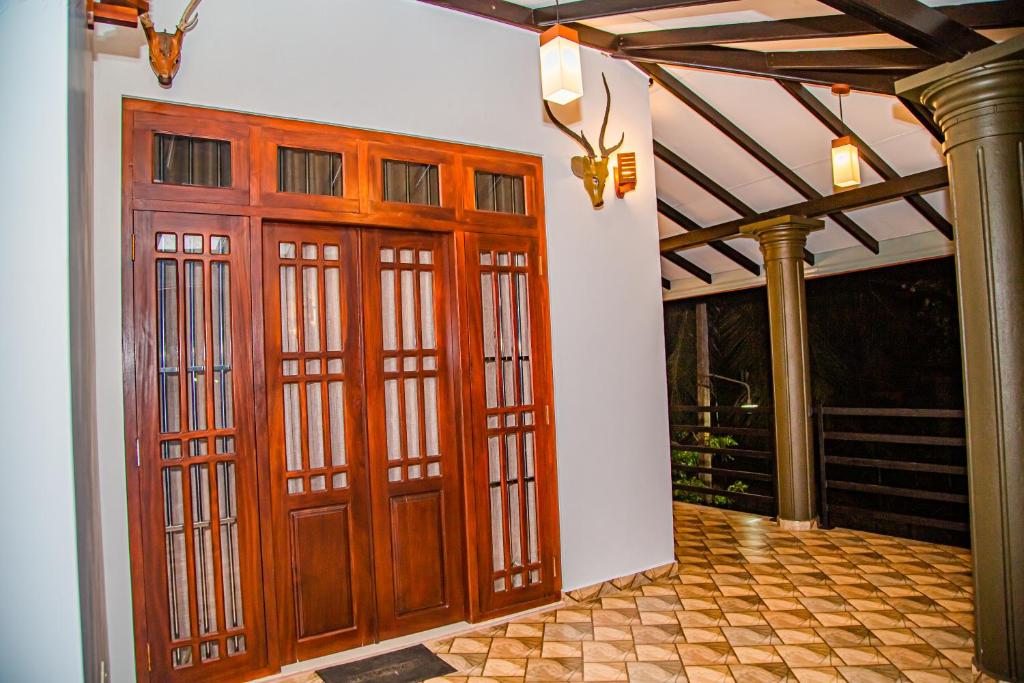 an entrance to a house with two wooden doors at Chala Villa in Ambalangoda