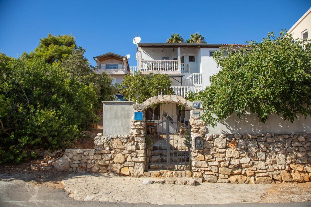 a stone wall with a gate in front of a building at Apartments by the sea Milna, Vis - 8895 in Rukavac