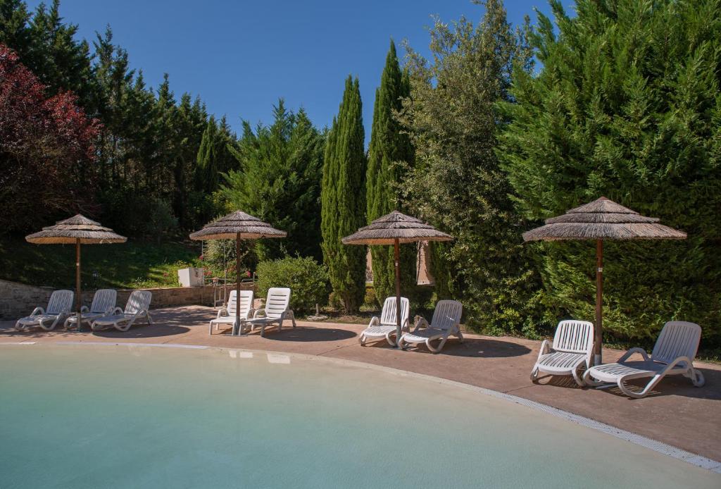 a group of chairs and umbrellas next to a pool at Boutique Country House Serendipity in Cantiano