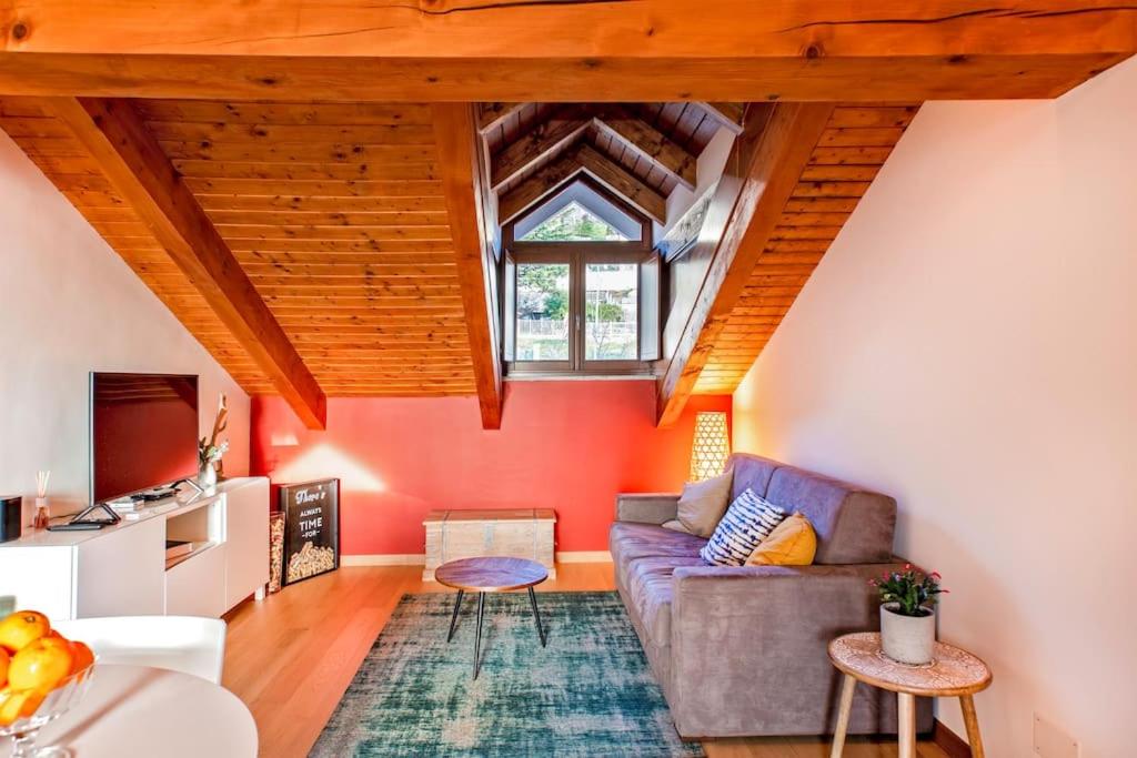 uma sala de estar com paredes vermelhas e um sofá em Charming 2.5Room Flat in Center of Monforte d'Alba em Monforte dʼAlba