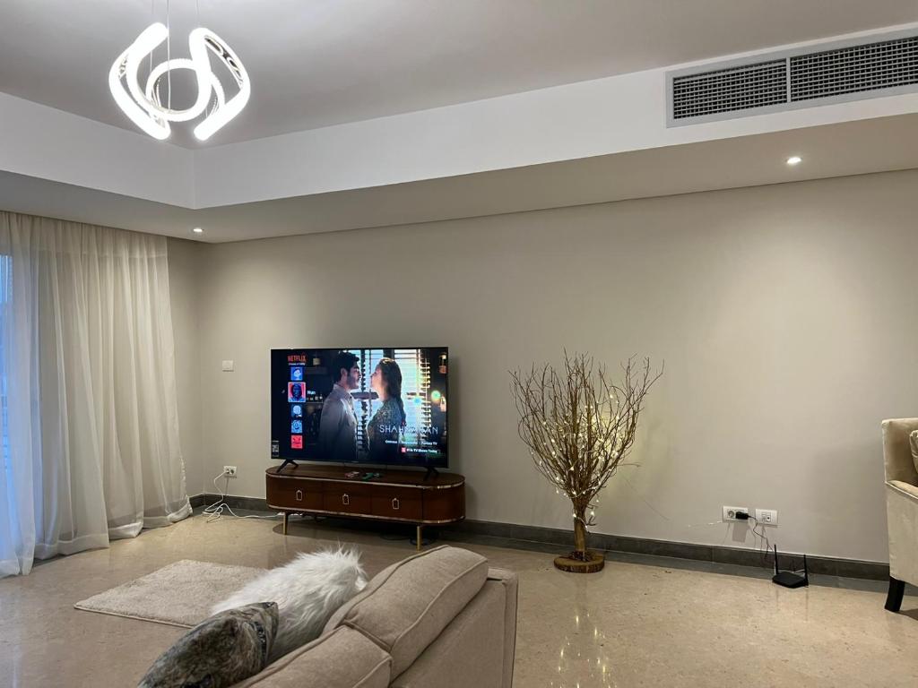 ein Wohnzimmer mit einem Sofa und einem Flachbild-TV in der Unterkunft Lovely Apartment New giza in Abū Rawwāsh